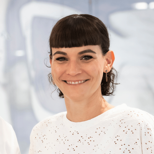 Lächelnde Frau in weißer Bluse im Büro